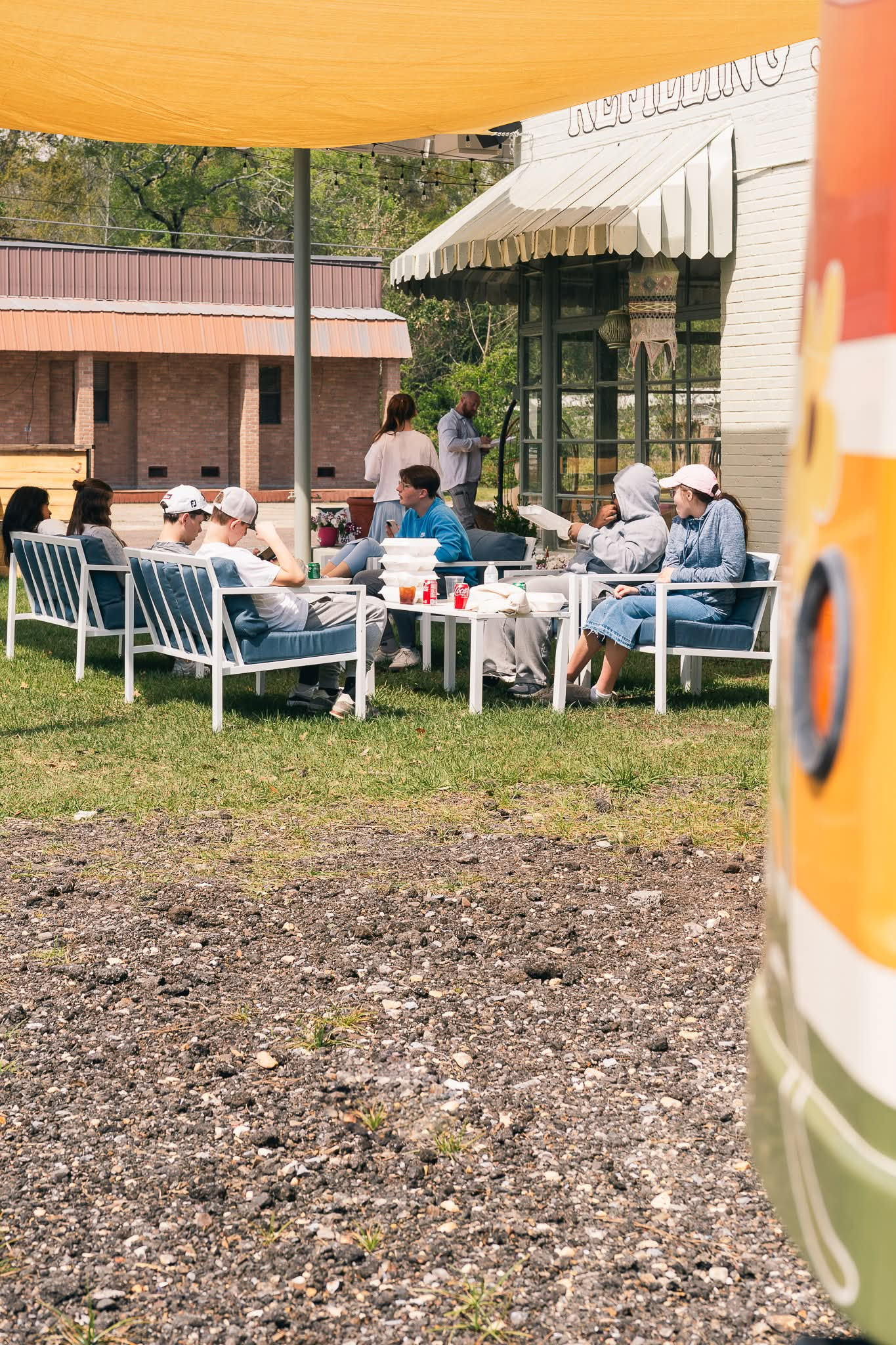 Customers relaxing and eating at outdoor seating next to Maggie's food truck