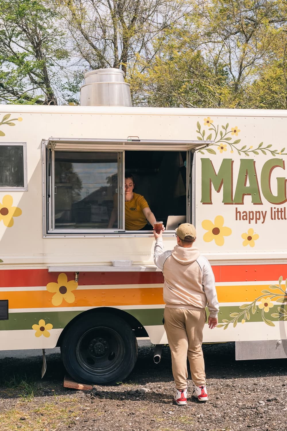 A customer picking up a fresh drink at the Maggie's food truck window